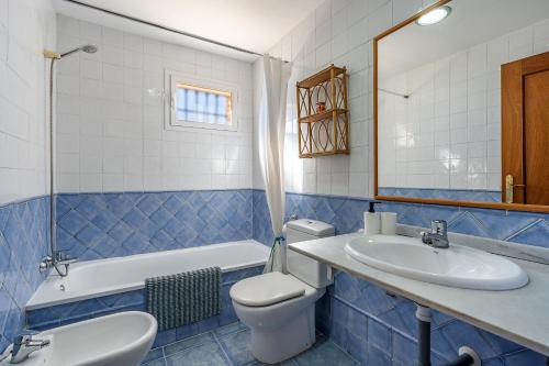 格拉纳达Casa Mirador Alquería的蓝色瓷砖浴室设有卫生间和水槽