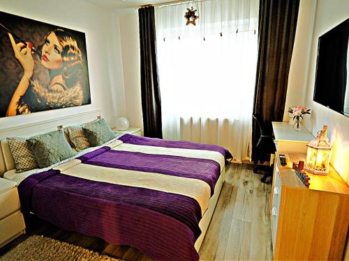 布拉索夫Relaxing Coresi Place的一间卧室设有紫色的床和大窗户