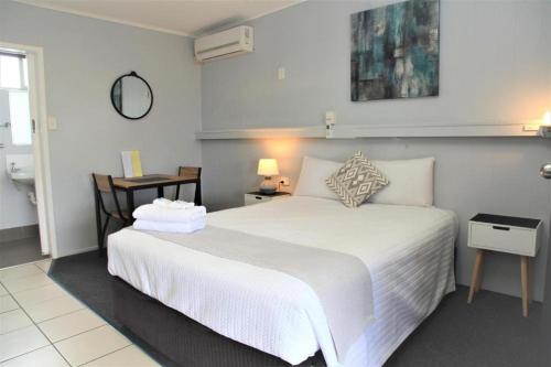 班达伯格魅力之城汽车旅馆的一间带白色大床的卧室和一间浴室