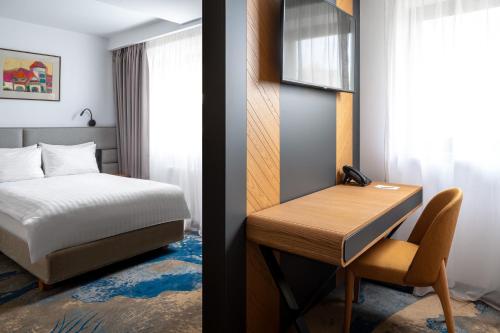 锡纳亚Alexandrion Experience的一间卧室配有一张床,一张桌子、一张床和一张书桌
