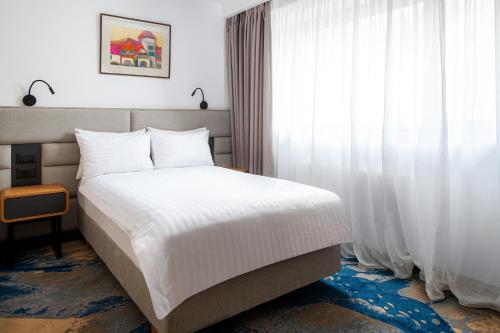 锡纳亚Alexandrion Experience的卧室配有白色的床和窗户。