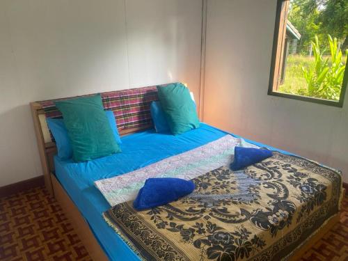 Muang KhôngKing Kong Restaurant and Bungalows的蓝色的床、蓝色枕头和窗户
