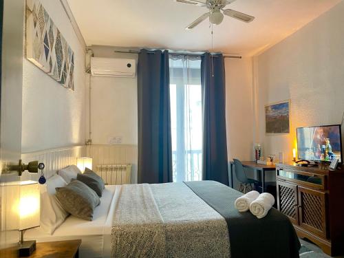 格拉纳达伊特尼尔旅馆的一间卧室配有一张带蓝色窗帘的床和一扇窗户