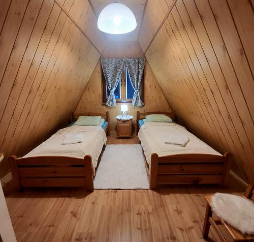 恰尔纳Domki Bieszczady Siedlisko Harenda的木屋内设有一间带两张床的卧室