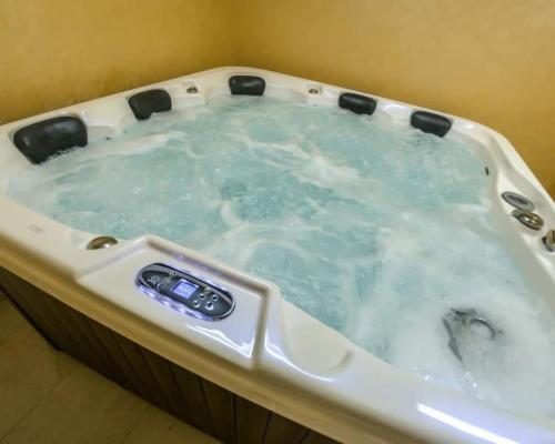 沙巴茨Smestaj & Spa Protić的充满蓝色水的按摩浴缸
