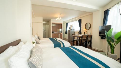 大阪ELLE Namba 7的酒店客房设有两张床和一张桌子。