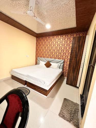 戈勒克布尔Hotel Shanti Grand Inn , Gorakhpur的一间小卧室,配有一张床和一把椅子