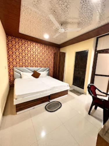 戈勒克布尔Hotel Shanti Grand Inn , Gorakhpur的一间卧室配有一张床和一把椅子