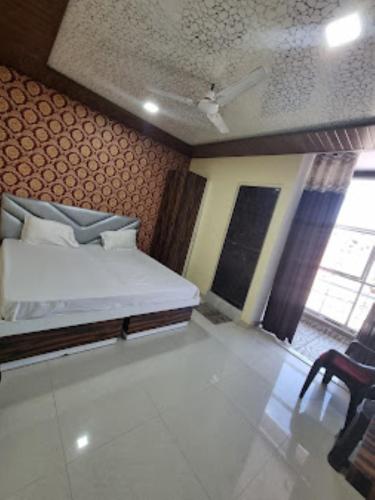 戈勒克布尔Hotel Shanti Grand Inn , Gorakhpur的小房间,配有一张床和一把椅子