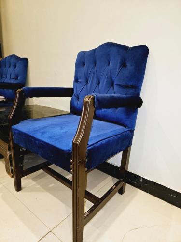 卡拉奇Rose Palace Hotel Karachi的一张蓝色椅子坐在桌子旁