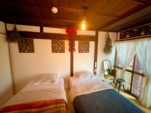 长野vintagehouse1925Bali - Vacation STAY 14502的带2扇窗户的客房内的2张床