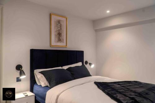 艾纯查姆Lovely 3-Bed Apartment in Altrincham的一间卧室配有一张带黑色床头板的床