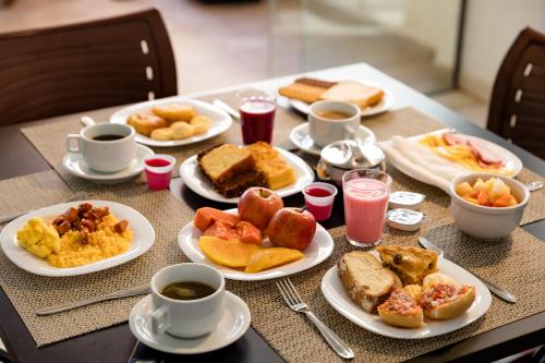 马塞约Moriah Maceió Beach Hotel的餐桌,带早餐食品盘和咖啡杯