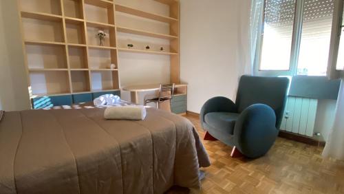 佛罗伦萨Cascine Park Florence Apartament的一间卧室配有一张床和一张蓝色椅子