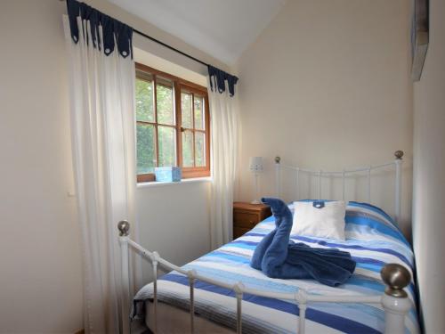 East Harling2 Bed in Thetford 64075的一间卧室,床上有一只蓝色填充动物