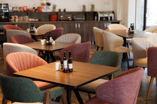 布什泰尼Suru Hotel & Restaurant的餐厅设有桌椅和瓶子