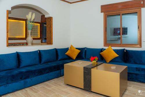舍夫沙万DAR BLANCA的客厅配有一张蓝色的沙发,配有一张桌子