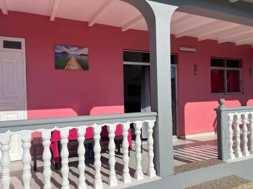 黑角Terrasse des Manguiers : logement indépendant的粉红色的房子,有白色的栅栏