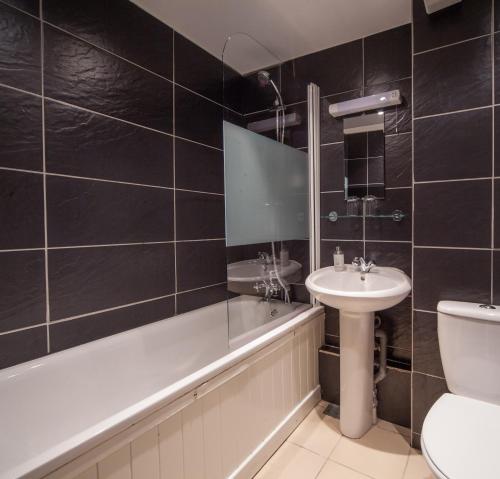 布里斯托The Rodney Hotel的一间带水槽、浴缸和卫生间的浴室