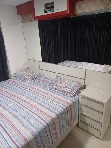 戈亚尼亚Brookfield Tower的小卧室配有带条纹床单的床