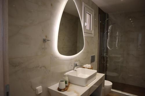 哈拉奇Merelia Luxury Guesthouse的一间带水槽、镜子和淋浴的浴室
