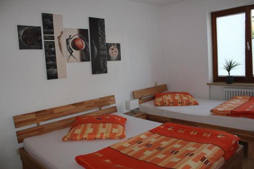 罗拉赫费恩渥诺沃提尼酒店的客房 - 带两张带橙色枕头的床