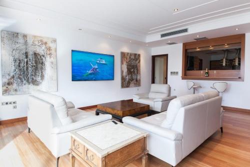 雅典Riviera Retreat 3 Bedroom Voula Luxury Haven Apt的客厅配有白色家具和壁画