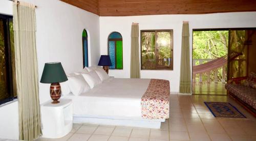 梅尔加Amanwana Ecofinca的卧室配有白色的床和窗户。