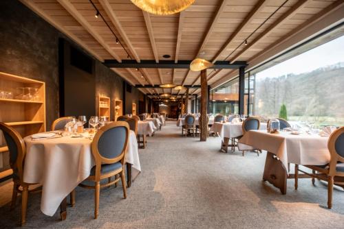 拉罗什-阿登克莱尔方丹国际之家酒店的餐厅设有白色的桌椅和大窗户