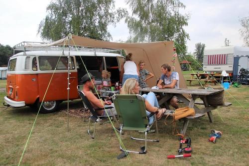 BeltrumMinicamping Falkenborg的一群人坐在一辆面包车前面的桌子上