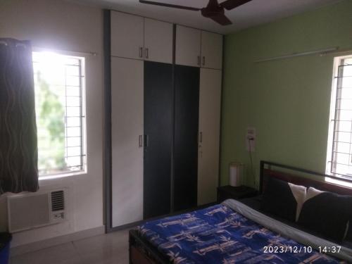 钦奈Royale Seaward Comfort Suites的一间卧室设有绿色的墙壁、一张床和两个窗户。