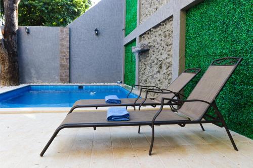 卡塔赫纳Hotel El Marqués De Manga的游泳池旁的两把椅子