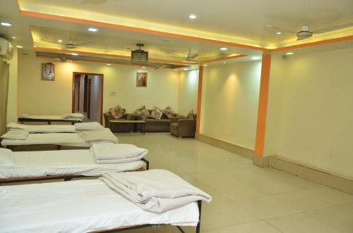 瓜廖尔Hotal Balaji的一张沙发的房间里一排床