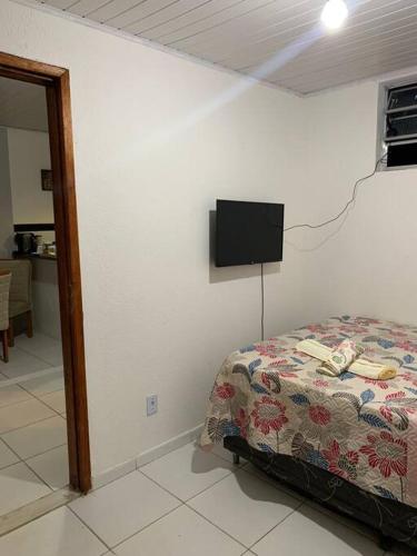 Rio LargoCasa próximo ao aeroporto的卧室配有一张床,墙上配有电视。