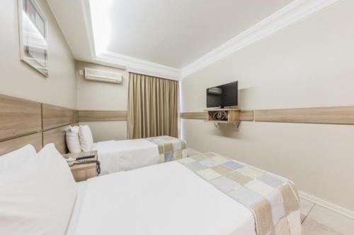 巴西利亚比塔广场酒店的一间酒店客房,设有两张床和电视