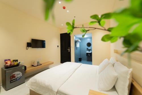 河内Khách sạn Gấu Hotel的卧室配有白色的床和电视。