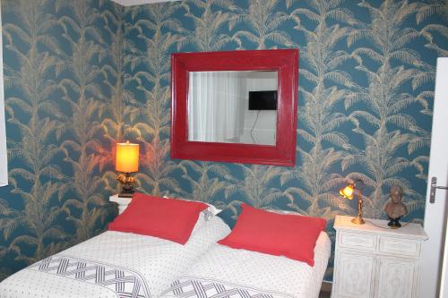 马拉科夫PARIS de FLORE Stane的一间卧室配有镜子和一张带红色枕头的床
