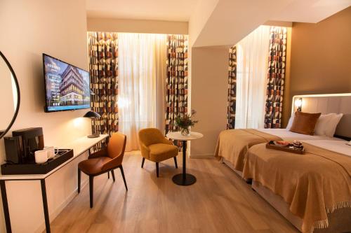 格拉斯哥The Address Glasgow的酒店客房配有一张床、一张书桌和一台电视。