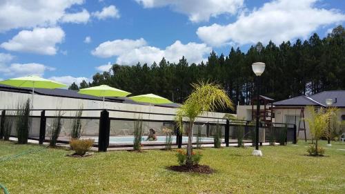 科隆Complejo Rincon del Uruguai的庭院内带绿伞的游泳池