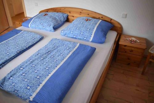 比苏姆Fewo Voßeler的一间卧室配有两张带蓝色枕头的床。