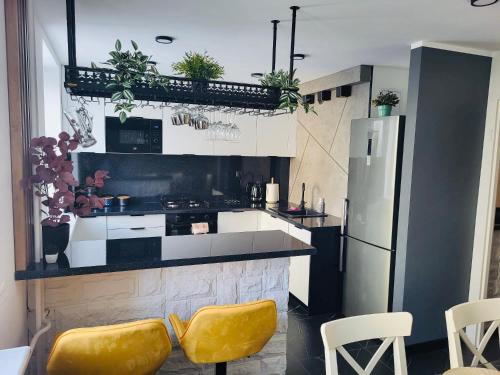 弗罗茨瓦夫New York Style Apartament 90 m2 we Wrocławiu的厨房配有黄色椅子和冰箱