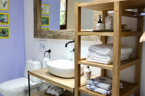 圣玛尔塔Solea Villa Tropical的浴室设有木制架子、毛巾和水槽