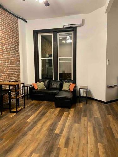 威廉波特Downtown Studio Apartment的客厅配有黑色沙发和窗户