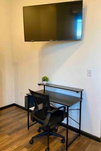 威廉波特Downtown Studio Apartment的一张桌子、椅子和墙上的电视