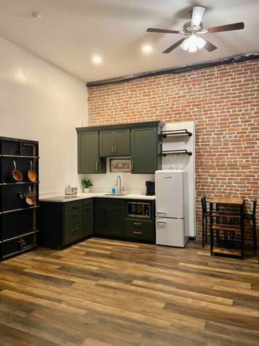 威廉波特Downtown Studio Apartment的厨房设有绿色橱柜和砖墙