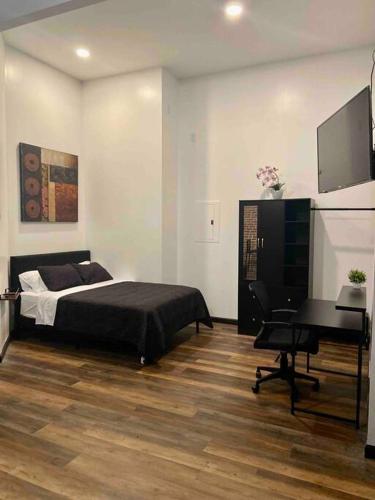 威廉波特Downtown Studio Apartment的一间卧室配有一张床、一张书桌和一台电视