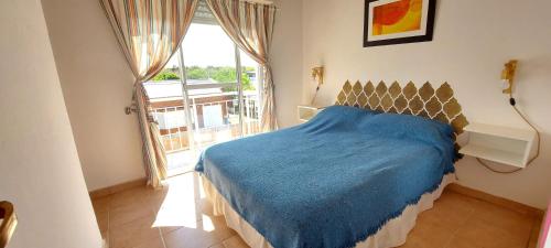 拉斯格路塔斯Las Grutas Star的一间卧室设有蓝色的床和大窗户