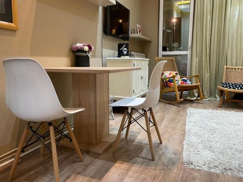 贝尔格莱德Downtown Zemun Studio Apartment的厨房配有2把白色椅子和桌子