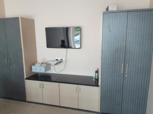 JammalamaduguRivera Resort的一间设有两个橱柜的房间和墙上的电视