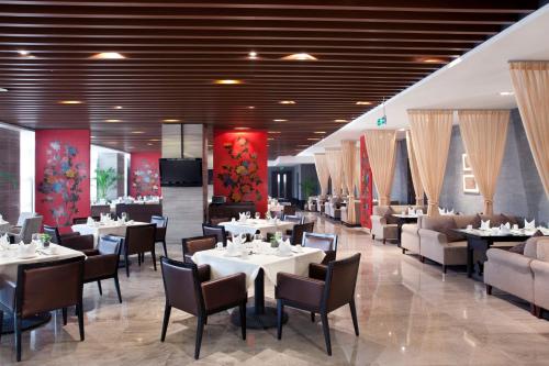 北京北京德胜门华宇假日酒店的一间设有白色桌椅的用餐室